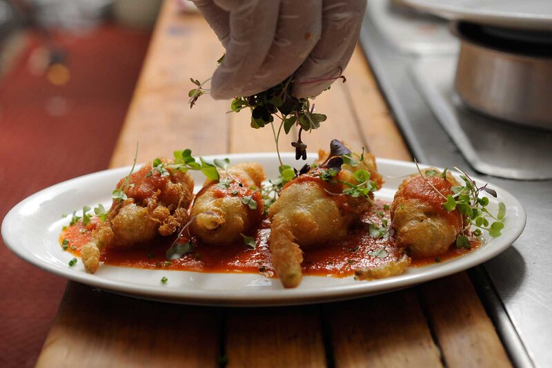 Fried jalapenos being garnished